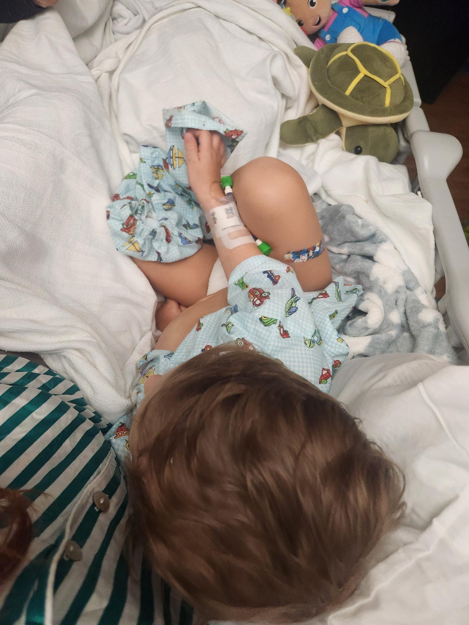 Max on a hospital bed with toys